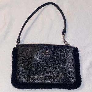 Black leather wristlet with fur edge.